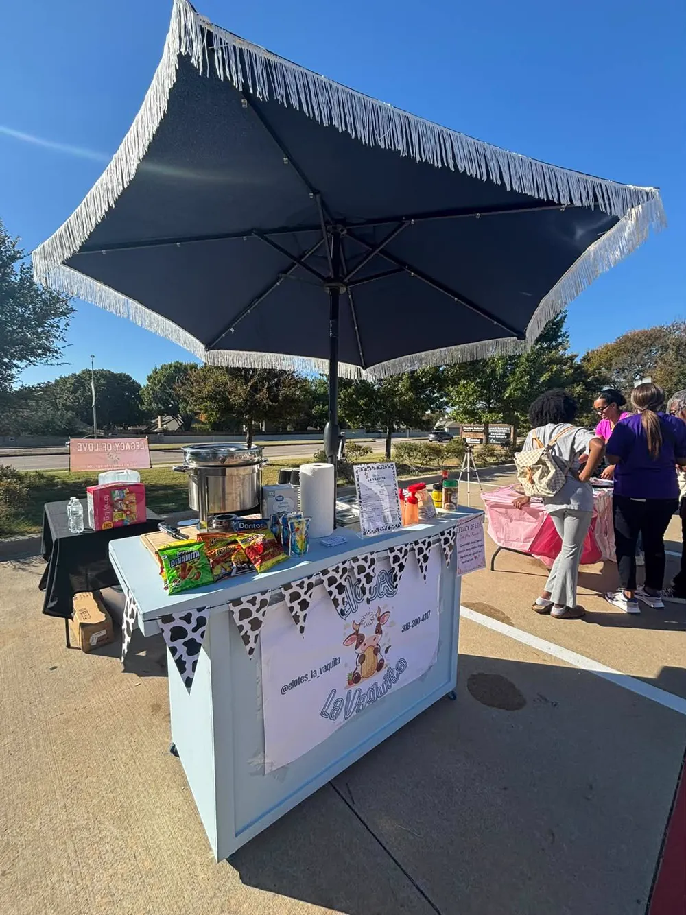 The light blue cart under a black fringe umbrella